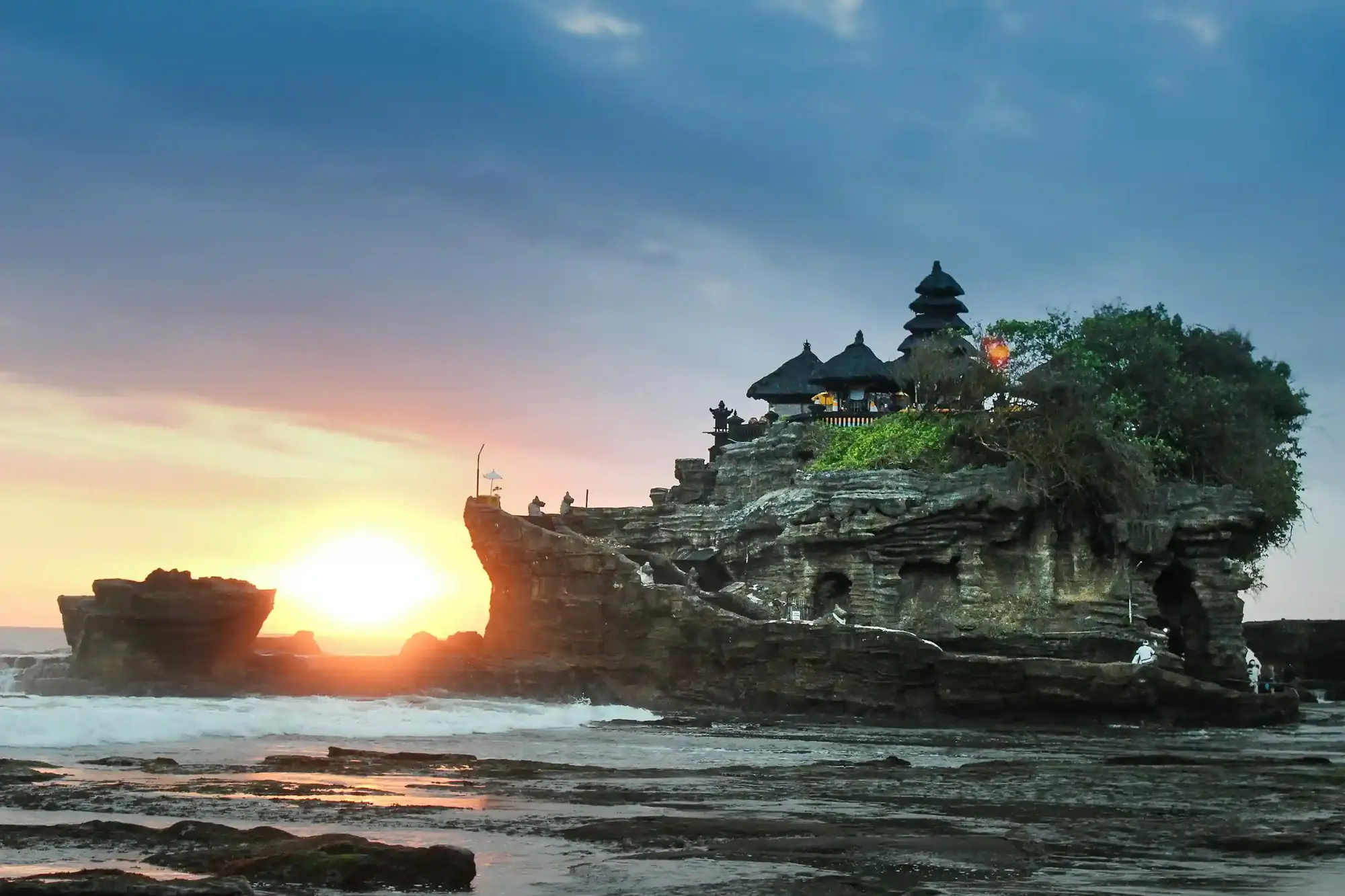 Sea temple on a rock silhouetted by a Bali sunset