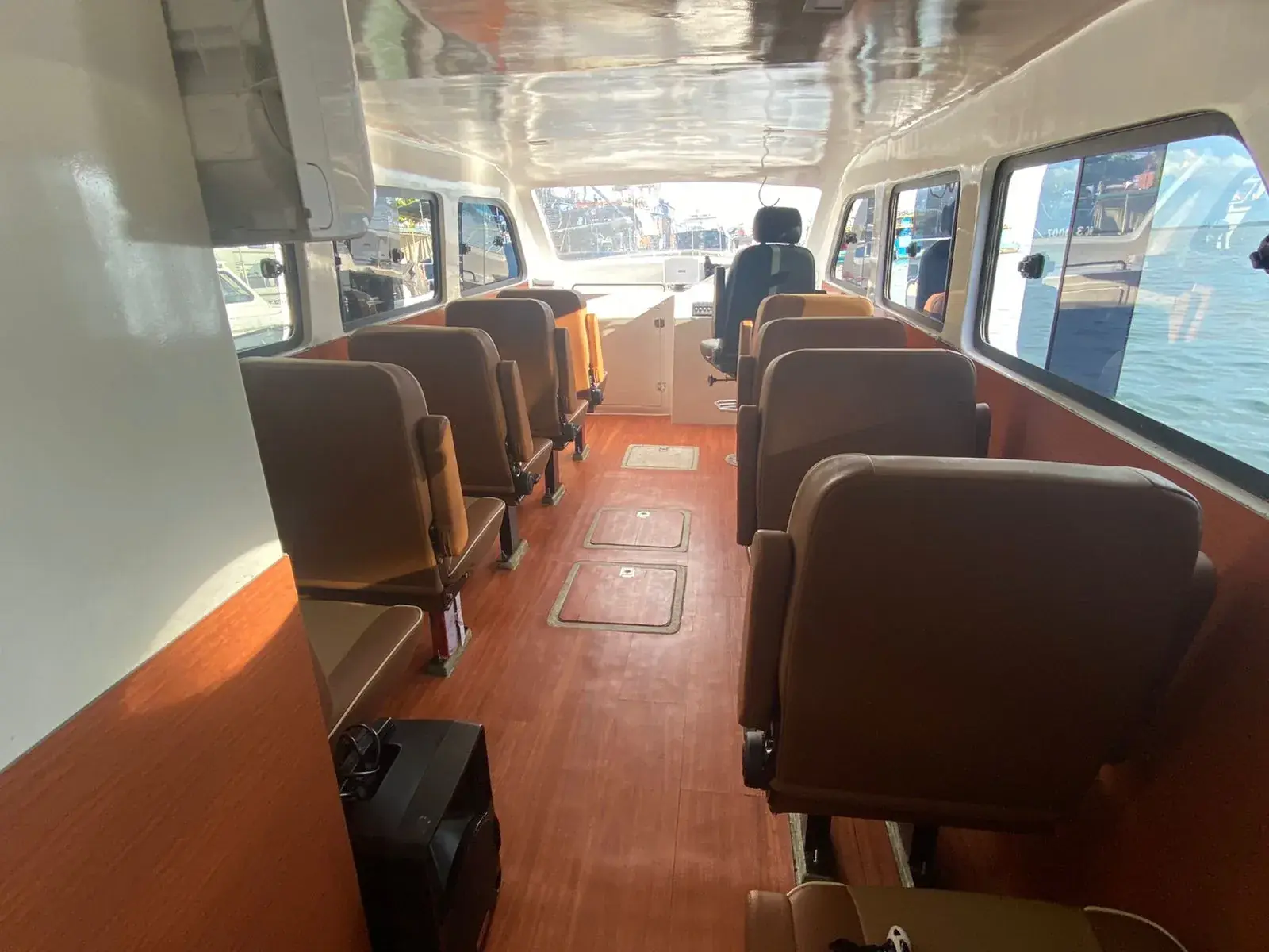Fast boat cabin with rows of cushioned seats and large windows