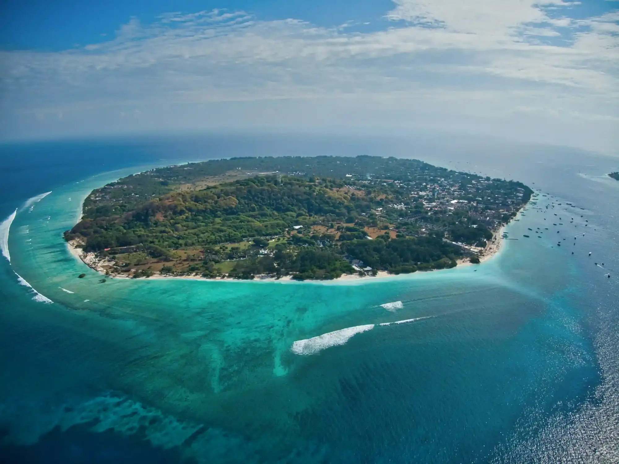 Aerial view of a Gili island ringed by turquoise reef and white sand