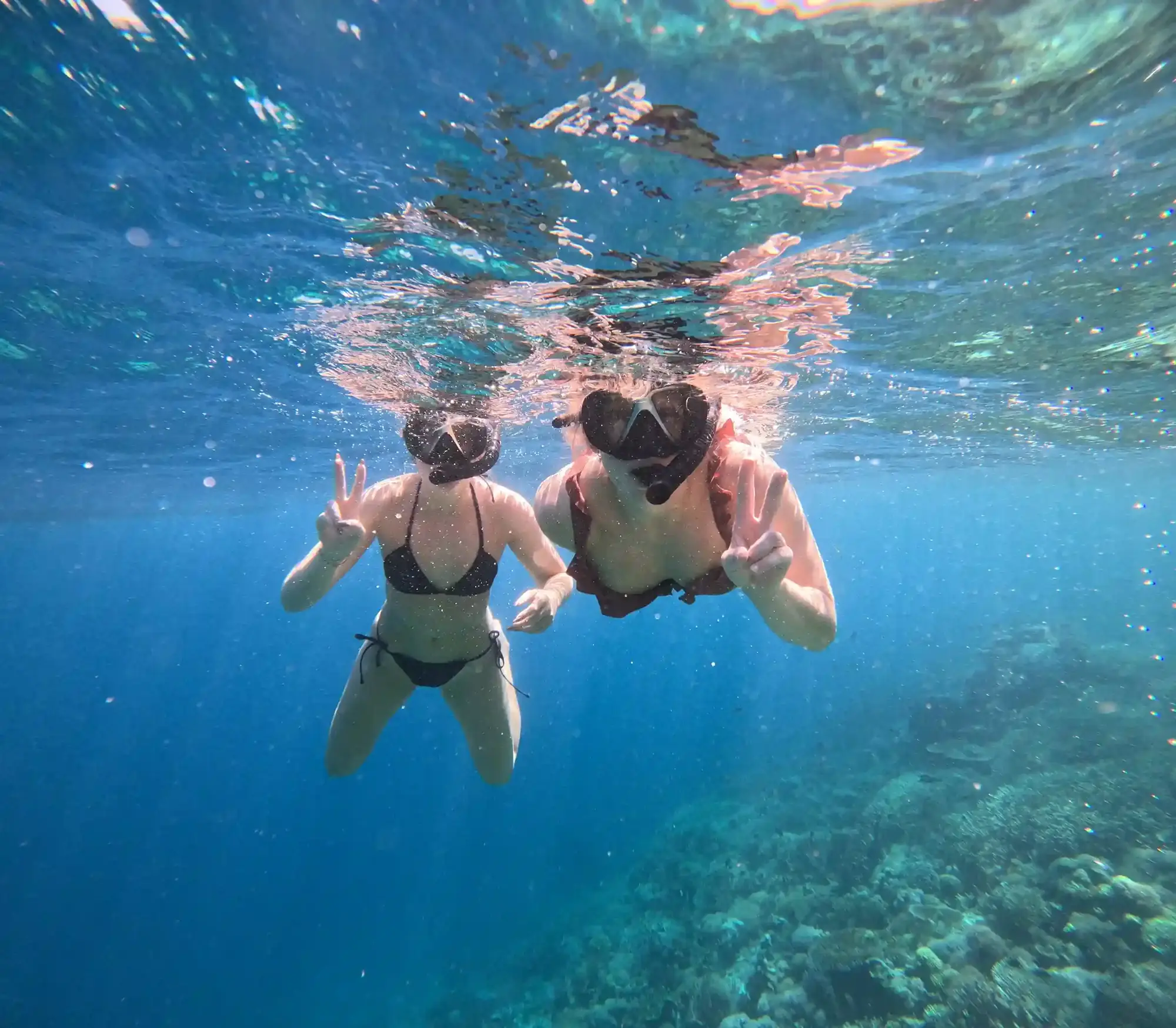 Two snorkellers smiling underwater